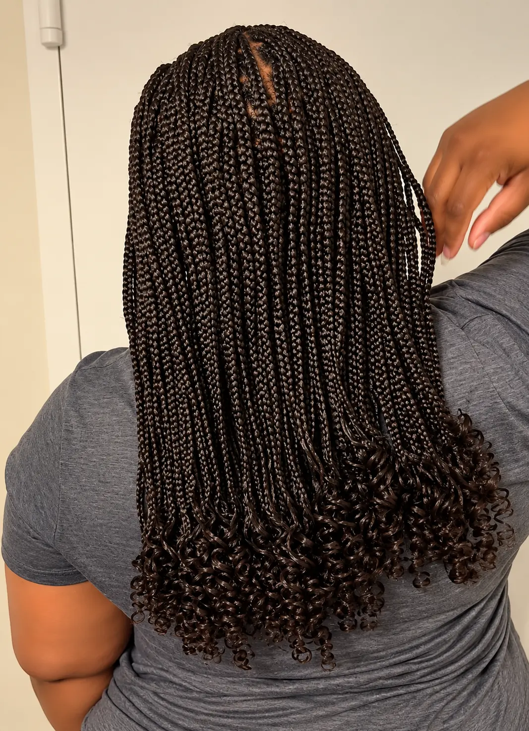 Shoulder-length dark brown braids with defined curled ends, back view