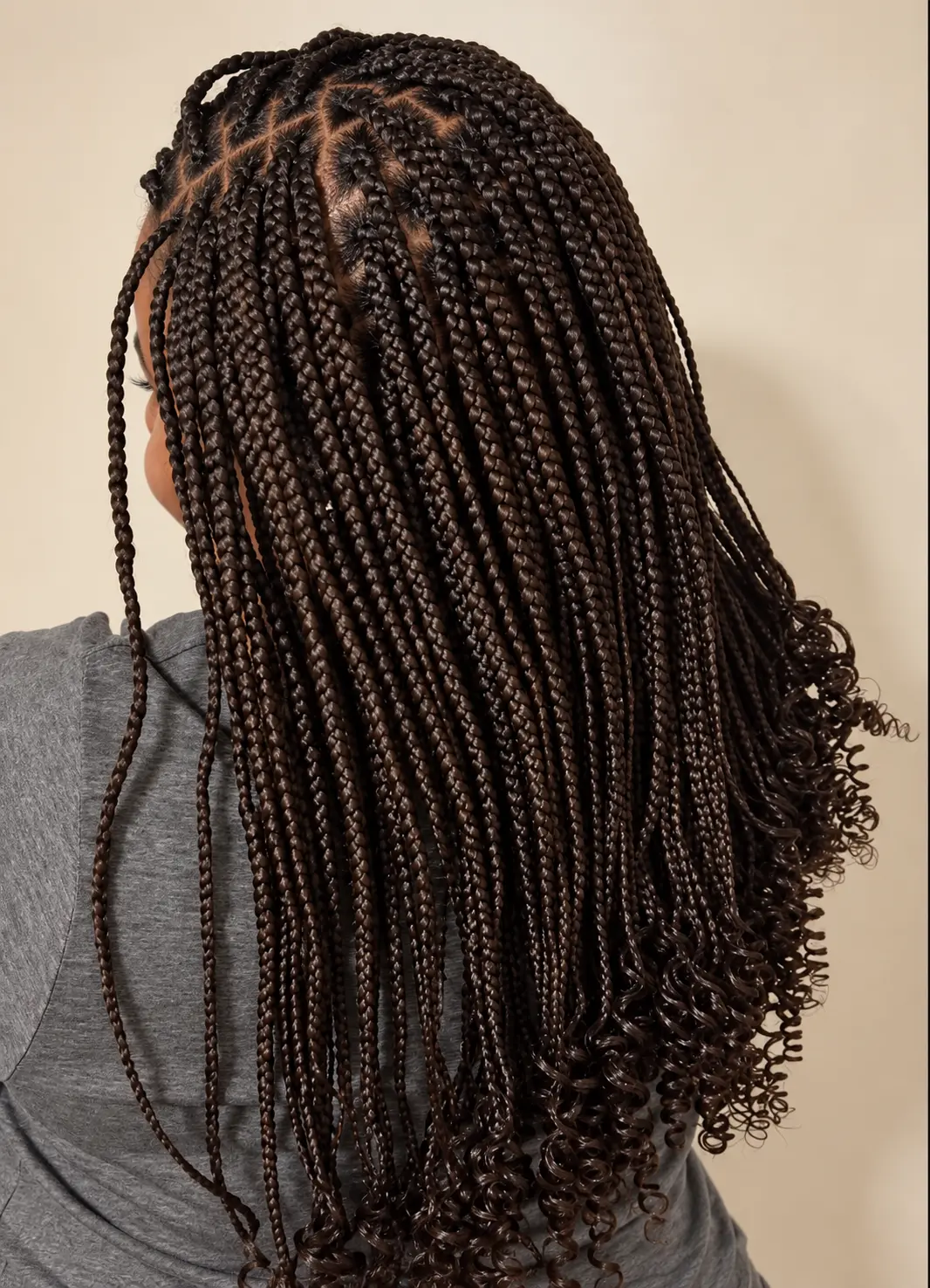 Shoulder-length dark braids with curled ends and clean parting, side view