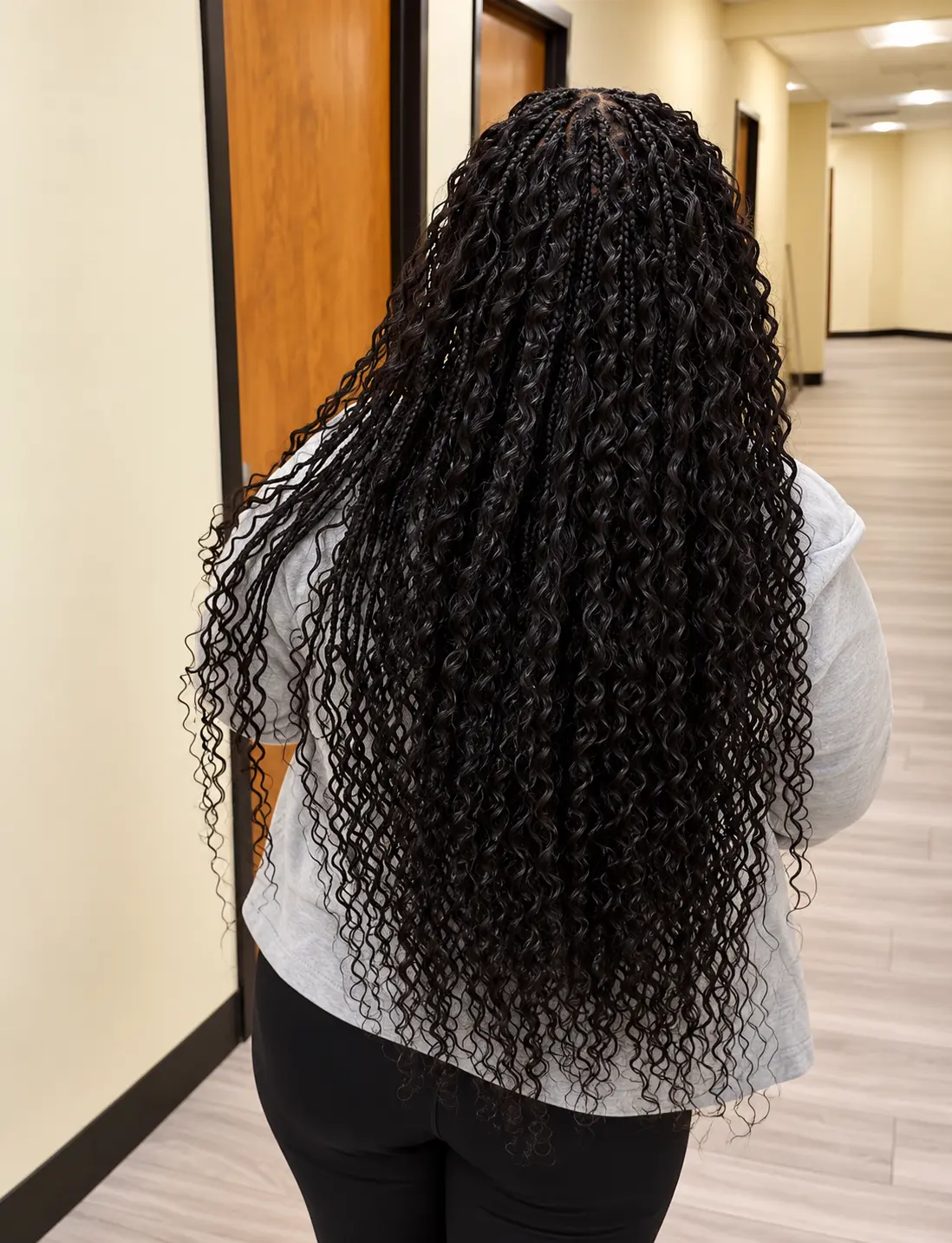 Long black boho knotless braids with loose curls, back view