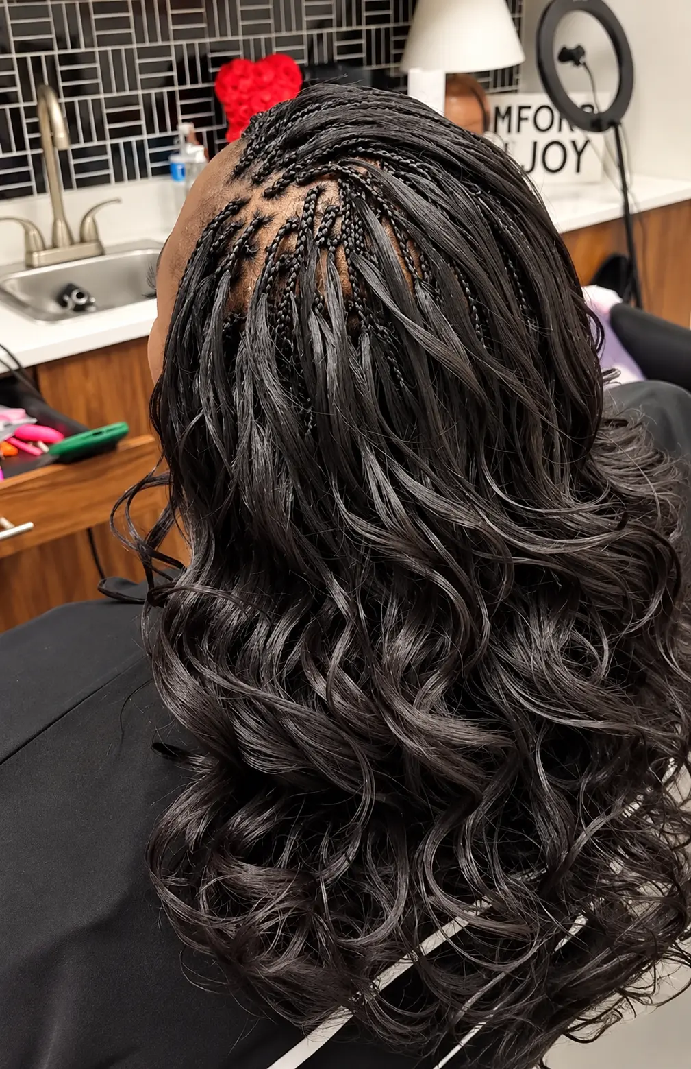 Small black braids with long wavy lengths, freshly finished in the salon