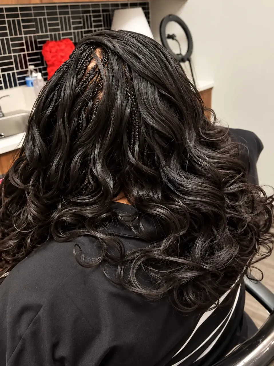 Small black braids flowing into soft wavy curls